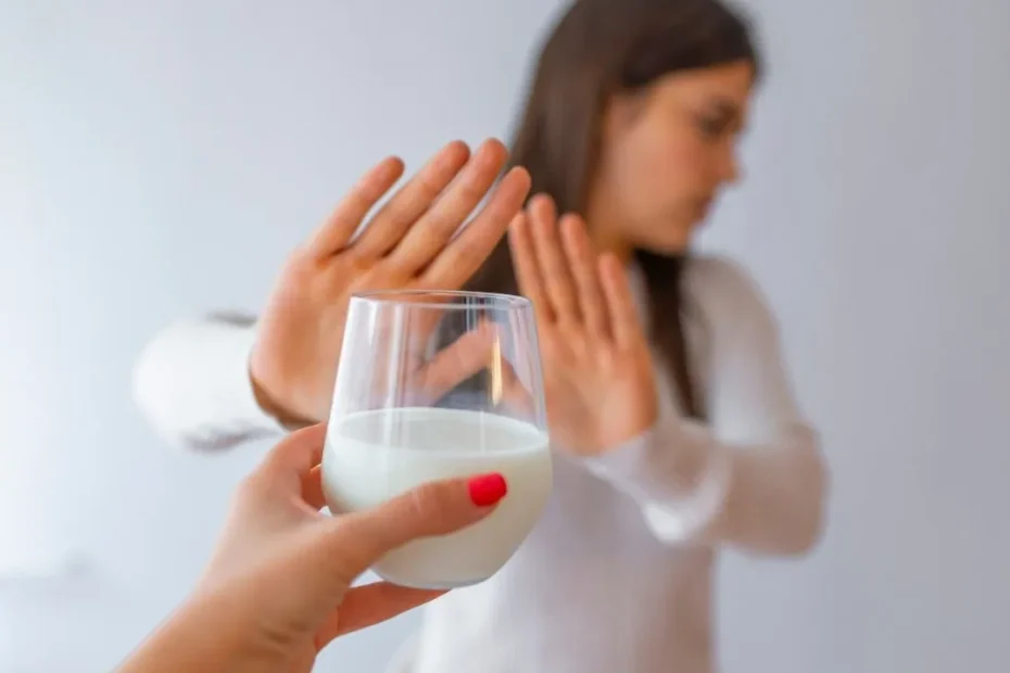 Donna che rifiuta un bicchiere di latte con un gesto della mano, a simboleggiare l'intolleranza al lattosio e la necessità di evitare i cibi che lo contengono.