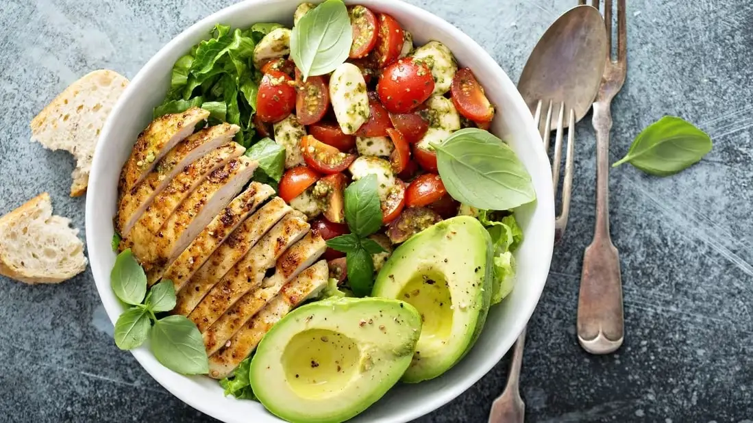 un piatto di alimenti salutari, tra cui pollo, avocado e pomodorini, ad indicare la dieta con mounjaro.
